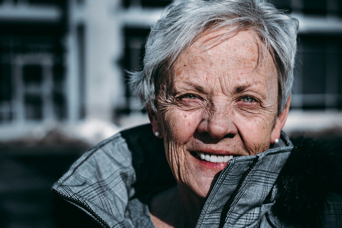 Smilende eldre kvinne utendørs